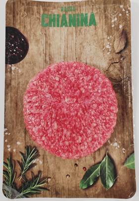 Hamburger bovino adulto di Chianina su un tagliere di legno con spezie e aromi.