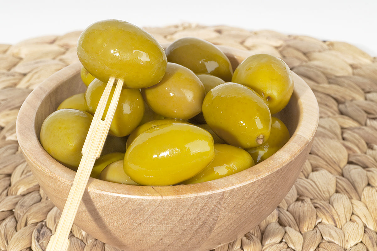 Olive Verdi Bella di Cerignola in a wooden bowl with chopsticks serving as an appetizer