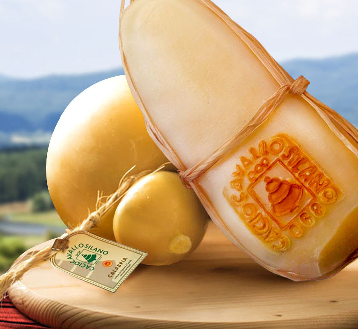 Caciocavallo Silano DOP cheese with yellow rind on a wooden board, showcasing its unique shape and label.