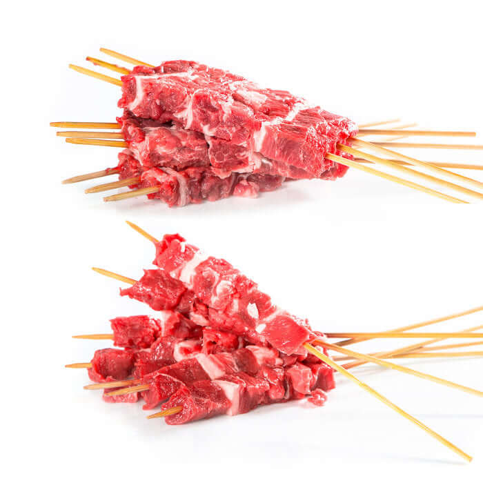 Arrosticini Abruzzesi preparati al momento con carne fresca su stecchi di legno.