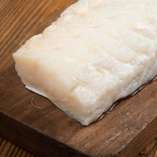 Filetto di Stoccafisso Ammollato Sotto Vuoto da 3 kg su tagliere di legno.
