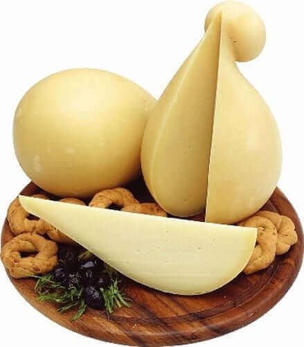 Caciocavallo di Ciminà cheese displayed on a wooden platter with cookies and herbs, highlighting its artisan quality.