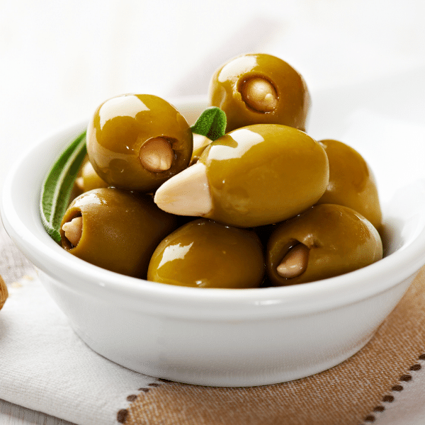 Olive Verdi Farcite con Mandorle alla siciliana in una ciotola bianca.