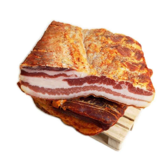 Pancetta Tesa Rossa Piccante della Sila 3 kg seasoned with salt, pepper, garlic, and pepper cream, displayed on a wooden surface.