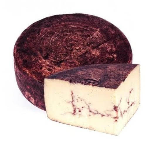Pecorino affinato al vino rosso Calabria IGT cheese wheel and wedge, showcasing its intense aroma and red wine aging.