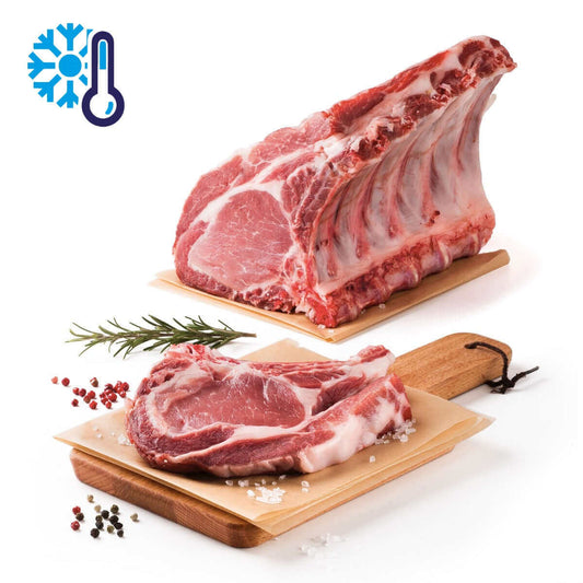 Costate di Maiale Semibrado Calabrese fresche, non congelate, su tagliere con aromi.