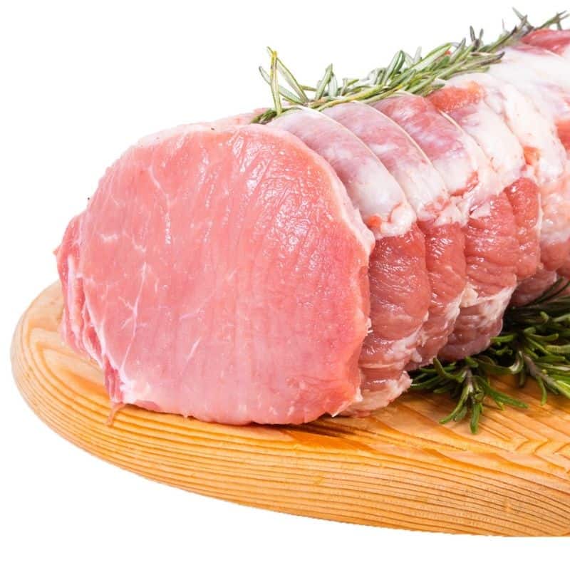 Arrosto Aromatizzato di Maiale Nero fresco e non congelato con rosmarino su tagliere di legno.