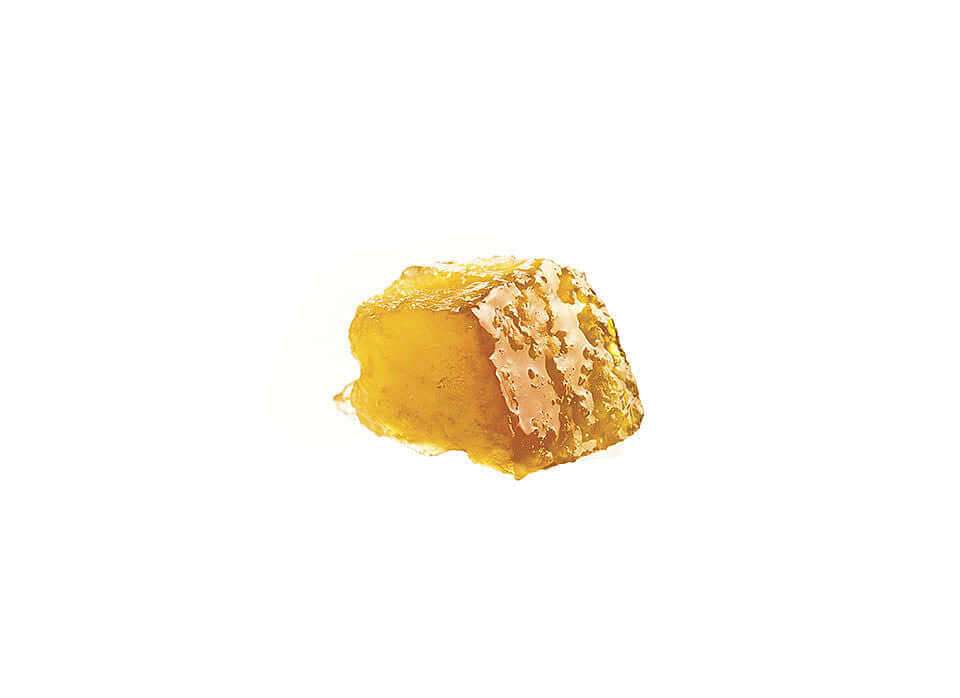 Golden edible honeycomb close-up on a white background.