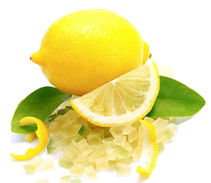 Fresh whole lemon and sliced lemon with green leaves and lemon zest pieces on white background.