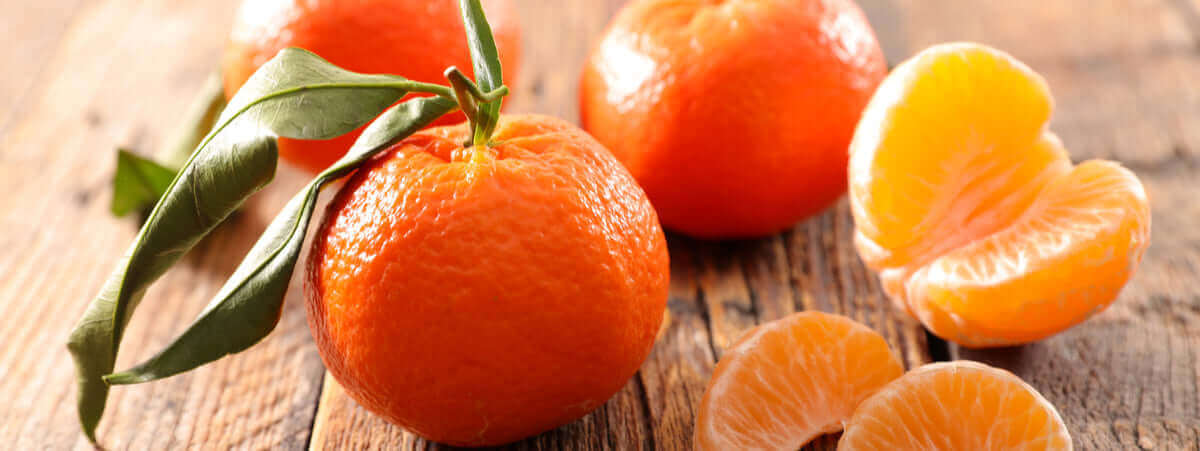 Clementine di Calabria fresche su un tavolo di legno, con spicchi dolci e foglie verdi.