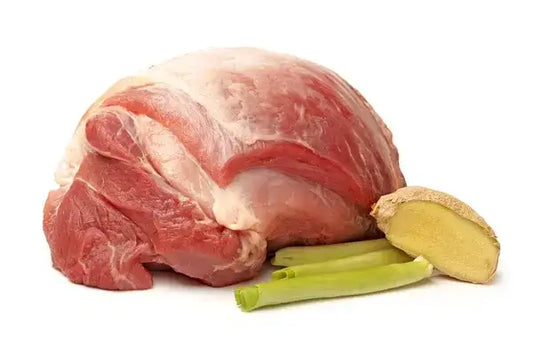 Raw pork shoulder with fresh ginger and green onions on white background.