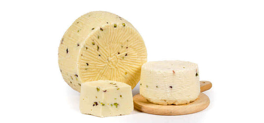 Formaggio Siciliano con Pistacchio primo sale di Sicilia 2 kg su tagliere con pistacchi interi.