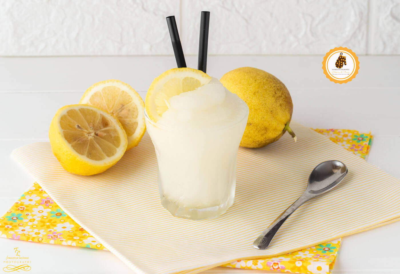 Glass of lemon sorbet with fresh lemons on a decorative napkin