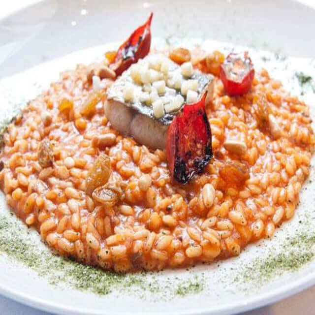 Riso di Sibari - Arborio di Calabria dish served with fish, garnished with dried tomatoes and herbs.