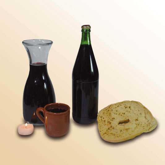 Vino Rosso Calabrese in a bottle and carafe with clay mug and bread, representing traditional dining.