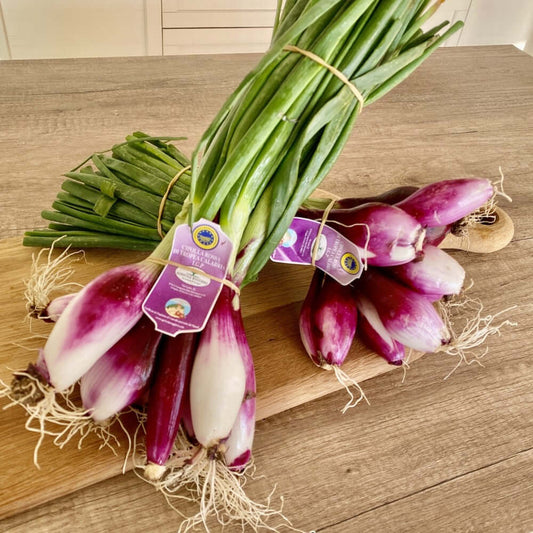 Cipolla Fresca di Tropea IGP mazzetti da 1 kg con cipollotti dolcissimi su un tavolo di legno.
