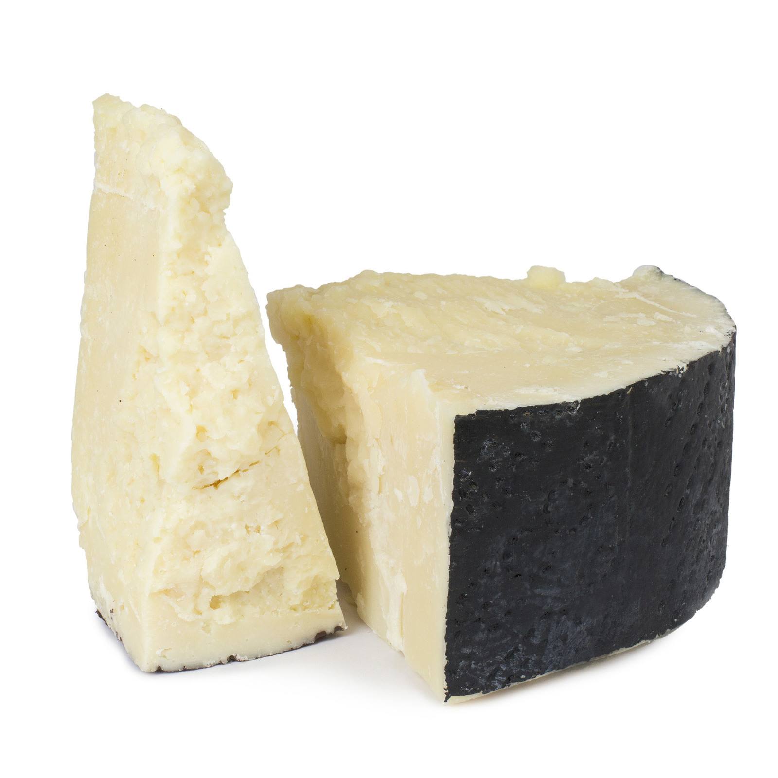 Wedge of aged Manchego cheese with crumbly texture and black rind