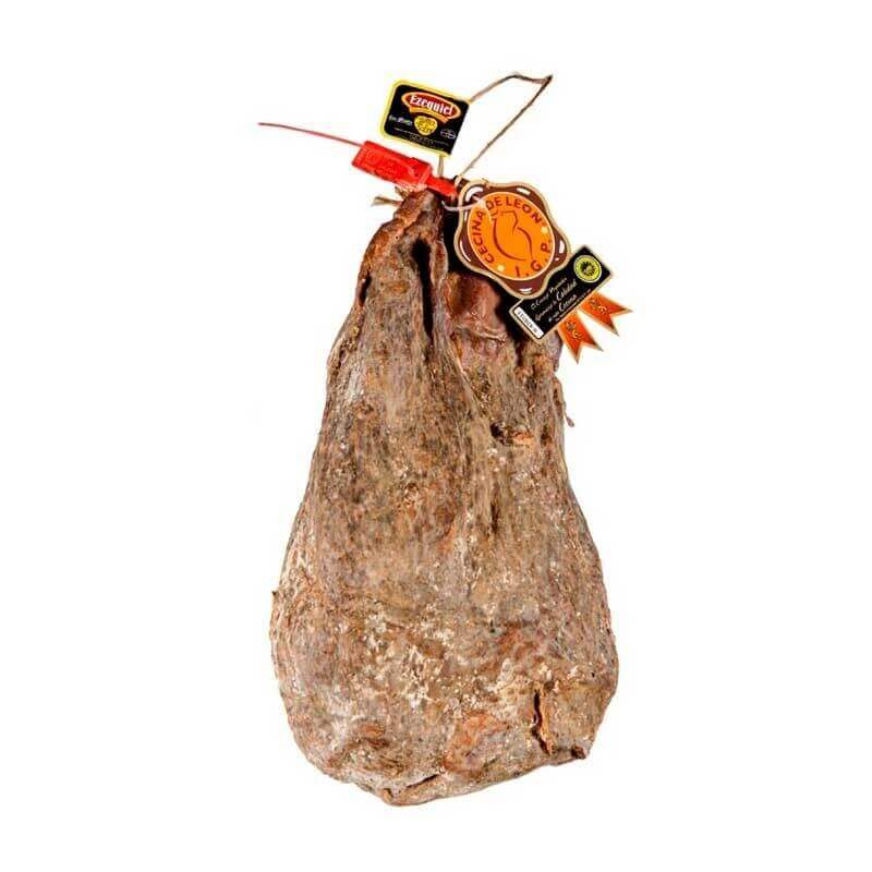 Cured ham with quality certification labels hanging from the top.